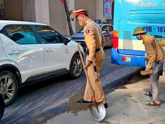 CSGT xử lý vết dầu máy loang dài 1km trên đường làm người dân trượt ngã - ảnh 2