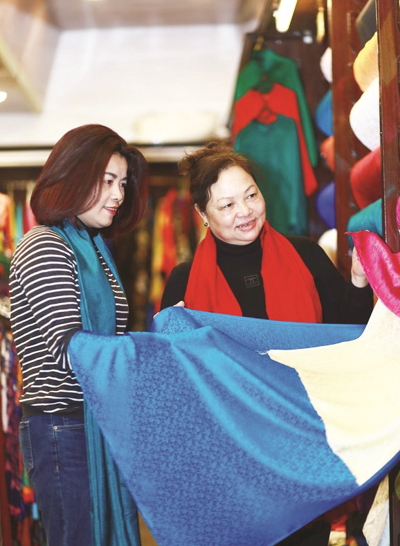 Nghệ nh&acirc;n Nguyễn Thị T&acirc;m giới thiệu sản phẩm tới kh&aacute;ch du lịch