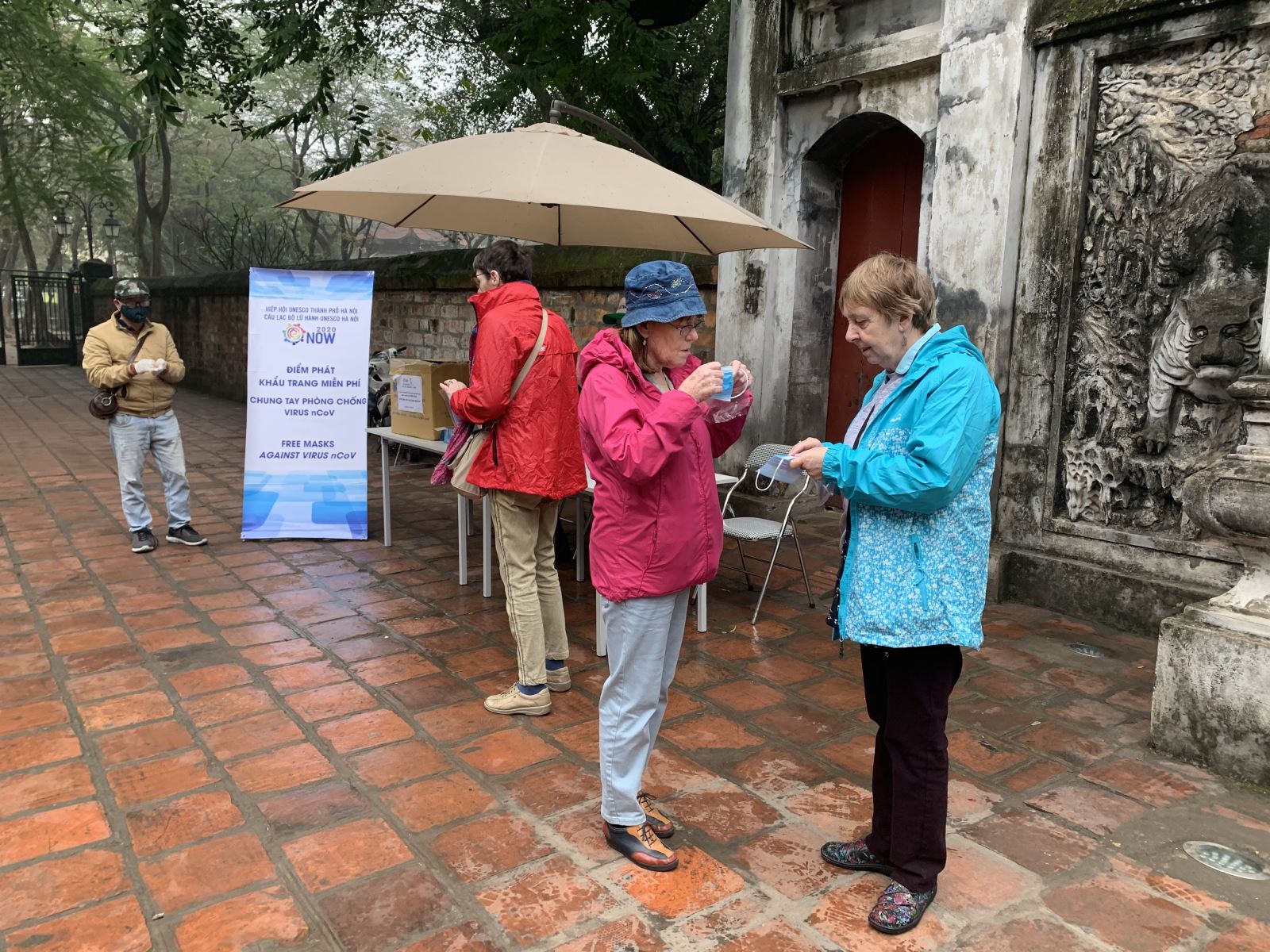 Du khách được tặng khẩu trang miễn phí trước khi vào tham quan tại Văn Miếu - Quốc Tử Giám