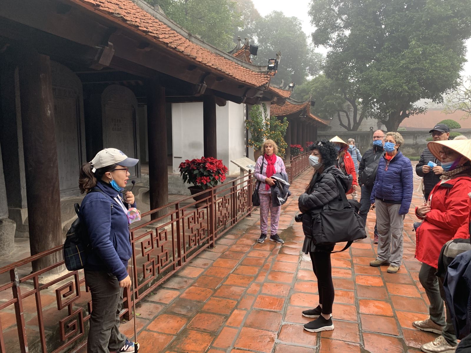 Hướng dẫn viên dẫn khách vào tham quan Văn Miếu - Quốc Tử Giám.