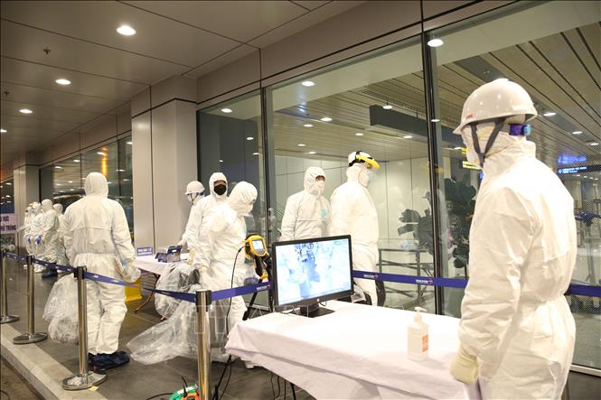 Kiểm tra thân nhiệt và tiêu độc, khử trùng người và phương tiện trước khi làm thủ tục nhập cảnh.