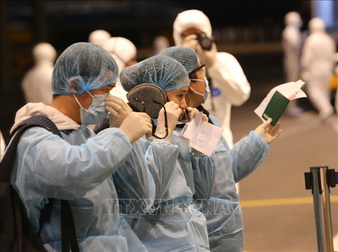 Công dân Việt Nam trở về từ Vũ Hán (Trung Quốc) được trang bị đồ bảo hộ và hướng dẫn làm thủ tục nhập cảnh tại sân bay Vân Đồn.