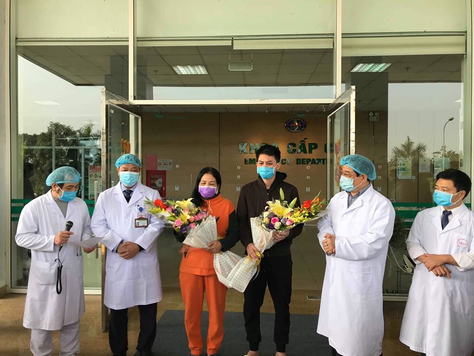 Đại diện Bộ Y tế và bác sĩ BV Bệnh nhiệt đới TƯ tặng hoa chúc mừng 2 bệnh nhân xuất viện