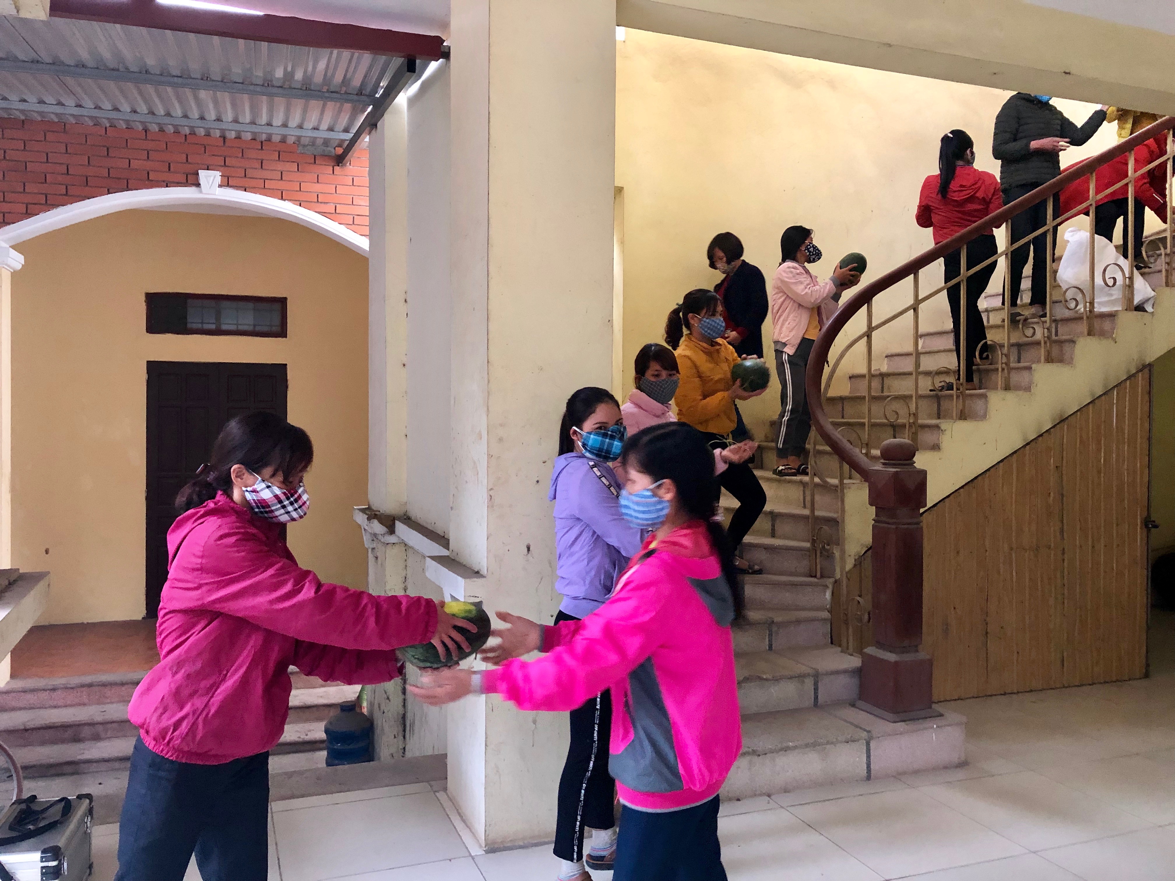 Những quả dưa hấu nghĩa tình được phụ nữ Minh Châu chuyền tay nhau mang vào hội trường trao tặng quà