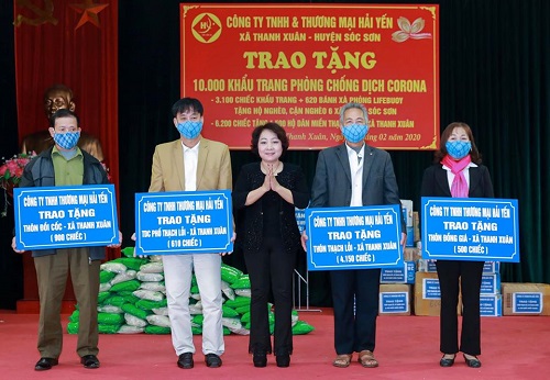 Doanh nh&acirc;n Hải Yến (người đứng giữa) trao tặng khẩu trang v&agrave; x&agrave; ph&ograve;ng s&aacute;t khuẩn cho người d&acirc;n S&oacute;c Sơn ph&ograve;ng chống dịch Covid-19