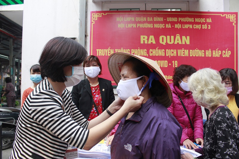 Người dân được cán bộ hướng dẫn cách sử dụng và đeo khẩu trang đúng cách để phòng chống bệnh Covid-19