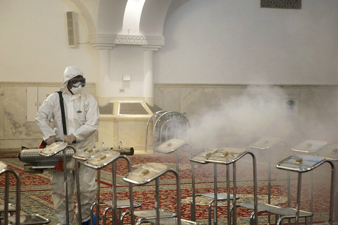 Nh&acirc;n vi&ecirc;n y tế phun thuốc khử tr&ugrave;ng đền thờ Imam Reza ở th&agrave;nh phố Mashhad, Iran ng&agrave;y 27.2.