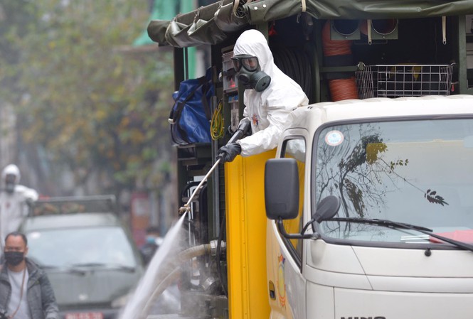 Lực lượng chức năng phun thuốc s&aacute;t tr&ugrave;ng, khử khuẩn tại khu vực c&oacute; người mắc Covid-19