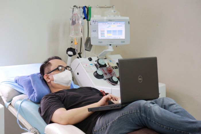 Hơn 20 lần hiến m&aacute;u v&agrave; tiểu cầu, anh Nguyễn Huy Ho&agrave;ng (Tương Mai, H&agrave; Nội) đ&atilde; l&agrave; người bạn quen thuộc của Viện mỗi khi c&oacute; người bệnh cần. Do thời gian hiến tiểu cầu l&acirc;u hơn (khoảng 1 tiếng), anh Ho&agrave;ng c&ograve;n tranh thủ mở laptop tư vấn cho kh&aacute;ch h&agrave;ng. Anh bảo dịch COVID n&ecirc;n đi đ&acirc;u cũng ngại, nhưng người bệnh cần l&agrave; đến th&ocirc;i.