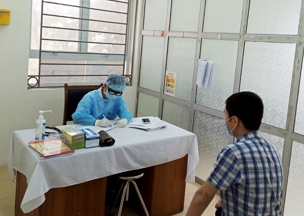 B&aacute;c sĩ TYT phường Đ&ocirc;ng Ngạc (quận Bắc Từ Li&ecirc;m) lấy th&ocirc;ng tin k&ecirc; khai y tế của người tiếp x&uacute;c gần với bệnh nh&acirc;n nghi nhiễm Covid-19 tr&ecirc;n địa b&agrave;n