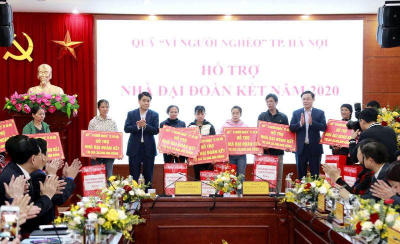 Bí thư Thành ủy Hà Nội Vương Đình Huệ, Chủ tịch UBND thành phố Hà Nội Nguyễn Đức Chung trao tiền hỗ trợ xây nhà Đại đoàn kết của Quỹ 