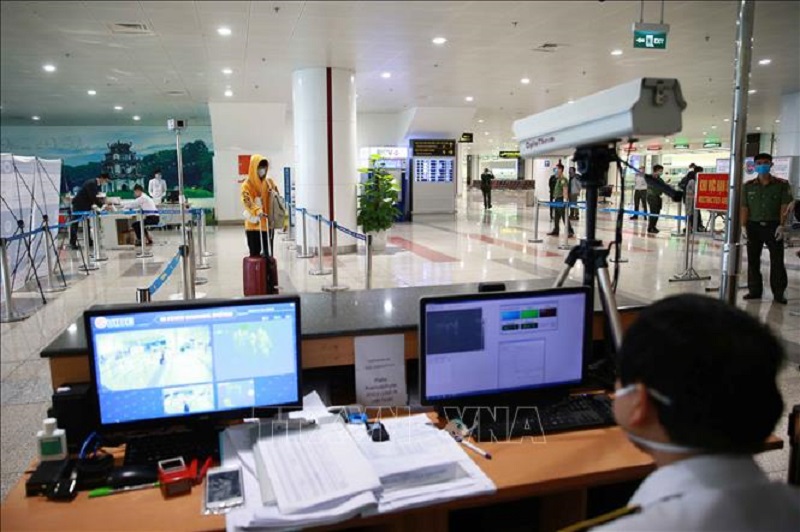 Lực lượng y tế kiểm tra th&acirc;n nhiệt đối với h&agrave;nh kh&aacute;ch nhập cảnh. Ảnh minh họa: Do&atilde;n Tấn/TTXVN