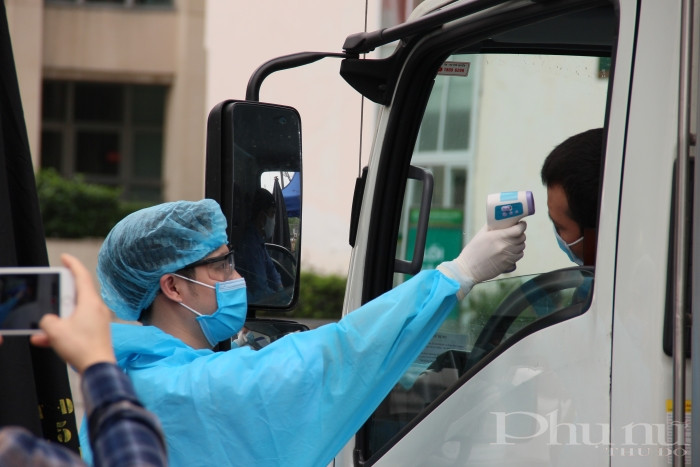 Kiểm tra thân nhiệt người ra vào tại BV Bạch Mai.