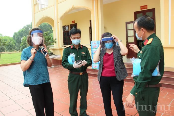 Các đồng chí trong Trung đoàn pháo binh 58 chia sẻ với chị em cán bộ Hội LHPN Hà Nội về sản phẩm kính chắn giọt bắn do đơn vị tự sáng chế, phục vụ công tác phòng dịch Covid-19.