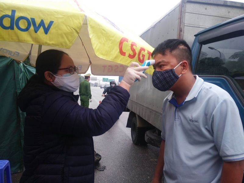 Cán bộ y tế tại chốt trực đo thân nhiệt của người điều khiển phương tiện