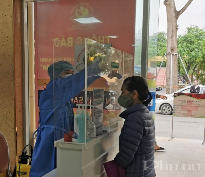 Mọi người ra, v&agrave;o tại bệnh viện Phụ sản H&agrave; Nội đều được đo th&acirc;n nhiệt, kiểm so&aacute;t dịch tễ chặt chẽ.