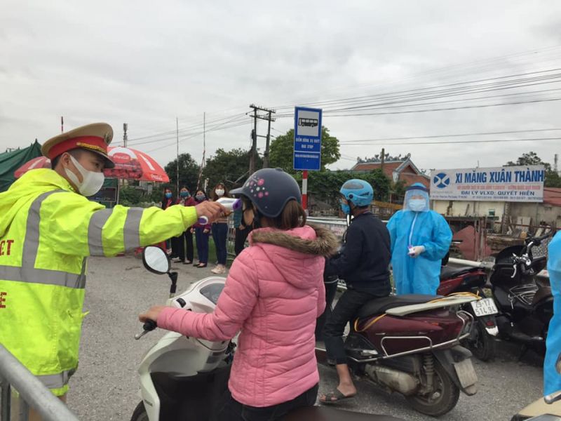 Cán bộ Tổ công tác tại chốt kiểm soát quốc lộ 1A đo thân nhiệt cho người tham gia giao thông Cán bộ Tổ công tác tại chốt kiểm soát quốc lộ 1A đo thân nhiệt cho người tham gia giao thông