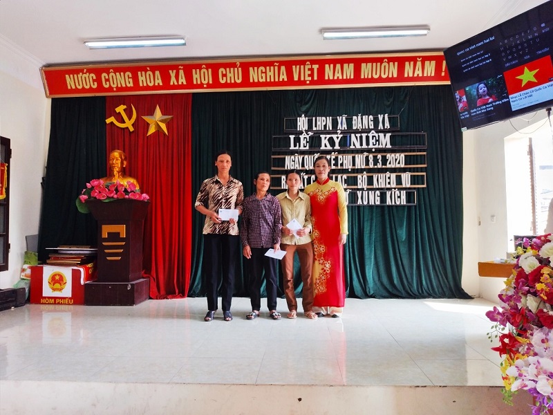 : Chị Ngô Thị Hồng Huệ, Chủ tịch Hội LHPN xã Đặng Xá (áo đỏ đứng thứ 2 từ bên trái sang) trao tặng sổ tiết kiệm cho gia đình hội viên có hoàn cảnh khó khăn. : Chị Ngô Thị Hồng Huệ, Chủ tịch Hội LHPN xã Đặng Xá (áo đỏ đứng thứ 2 từ bên trái sang) trao tặng sổ tiết kiệm cho gia đình hội viên có hoàn cảnh khó khăn.