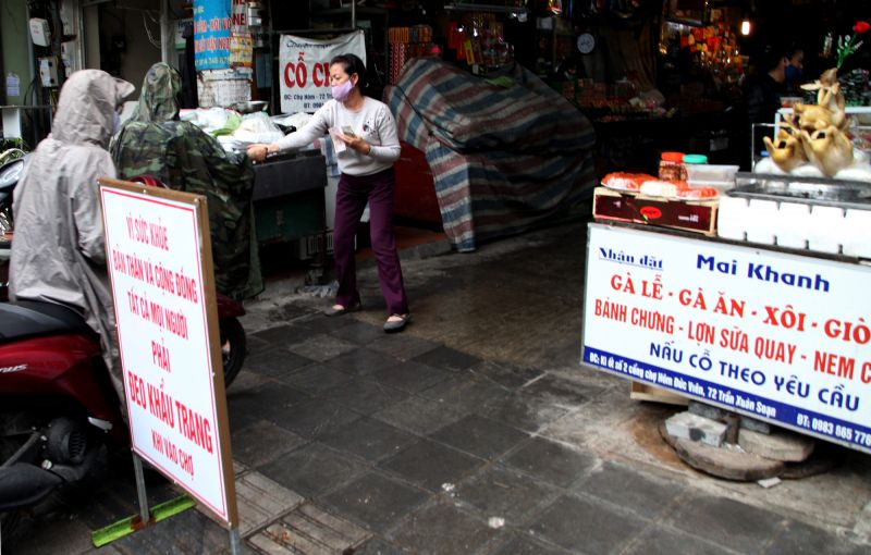 Tấm biển nhắc nhở người dân đeo khẩu trang được đặt ngay tại một cửa ra vào của chợ Hôm - Đức Viên