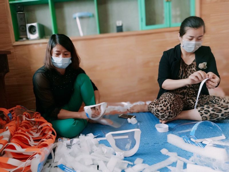 Hội viên phụ nữ huyện Mê Linh tự làm kính chống giọt bắn ủng hộ lực lượng phòng dịch ở thôn Hạ Lôi