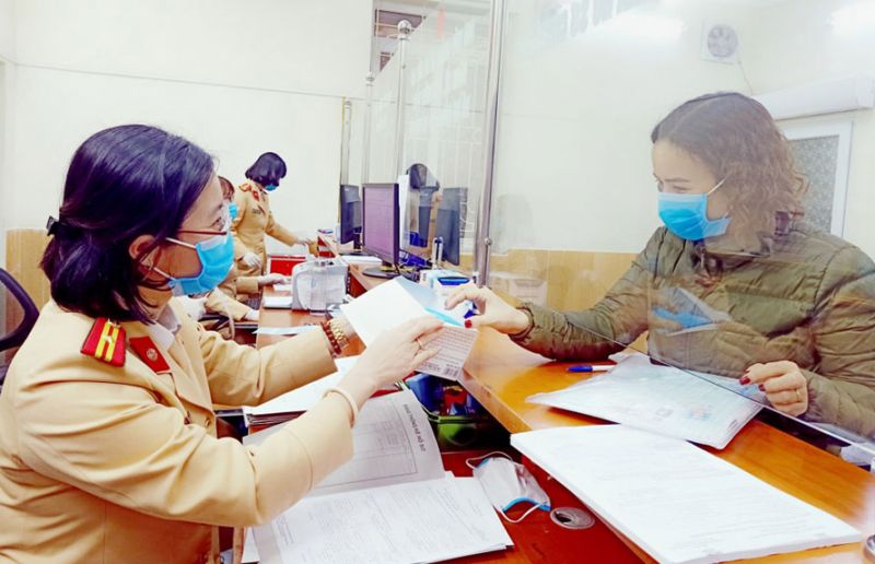 Lực lượng Cảnh s&aacute;t giao th&ocirc;ng H&agrave; Nội giải quyết thủ tục, trả giấy tờ, h&oacute;a đơn cho người vi phạm.