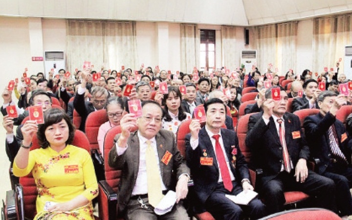 C&aacute;c đại biểu biểu quyết th&ocirc;ng qua dự thảo Nghị quyết v&agrave; Chương tr&igrave;nh h&agrave;nh động của Đảng bộ phường Cầu Diễn, nhiệm kỳ 2020-2025.Ảnh: QUANG VINH