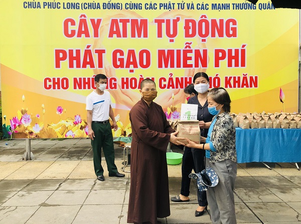 Thầy Thích Đàm Hoài, trụ trì chùa Phúc Long cùng Phó Chủ tịch MTTQ huyện Thanh Trì Nguyễn Thị Thắm trao phát gạo miễn phí cho người dân khó khăn