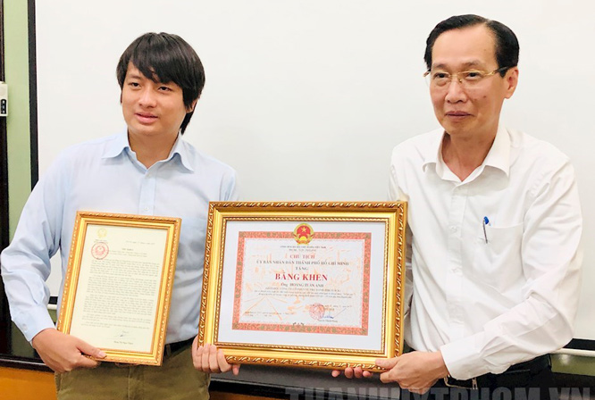 Thừa ủy quyền Phó Chủ tịch nước, Phó Chủ tịch Thường trực UBND thành phố Hồ Chí Minh Lê Thanh Liêm (bên phải) trao Thư khen cho anh Hoàng Tuấn Anh.