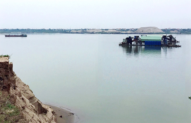 Tàu khai thác cát trái phép hoạt động trên sông Hồng, khu vực giáp ranh xã Xuân Đình, huyện Phúc Thọ (thành phố Hà Nội) với xã Đại Tự, huyện Yên Lạc (tỉnh Vĩnh Phúc). Ảnh: Nguyễn Công