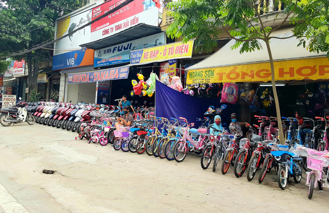 Vỉa hè quốc lộ 21B đoạn qua thị trấn Vân Đình (huyện Ứng Hòa) bị nhiều hộ lấn chiếm để bày bán hàng. Ảnh: Gia Huy