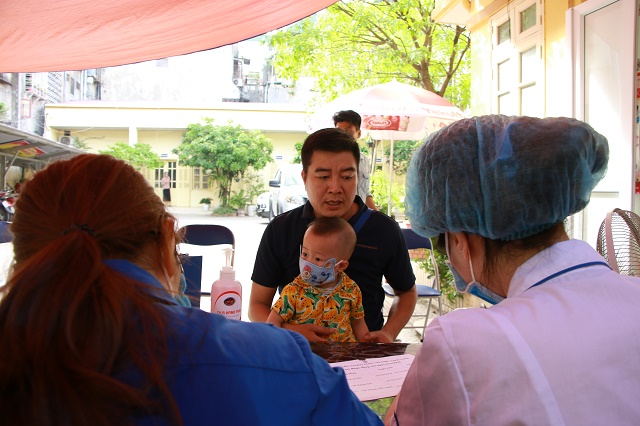 Tại Trạm Y tế phường hàng Bột, quận Đống Đa nhiều ông bố đưa con tới uống Vitamin A và cân đo, đánh giá tình trạng dinh dưỡng.