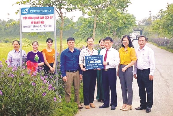 Lãnh đạo Huyện ủy, Hội LHPN huyện Sóc Sơn gắn biển và trao thưởng cho “Tuyến đường tự quản Xanh - sạch - đẹp, nở hoa kiểu mẫu” của xã Phú Cường