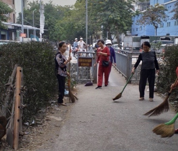 Cán bộ, hội viên khu dân cư thực hiện vệ sinh môi trường tại cây bầu bắc qua sông Gạo