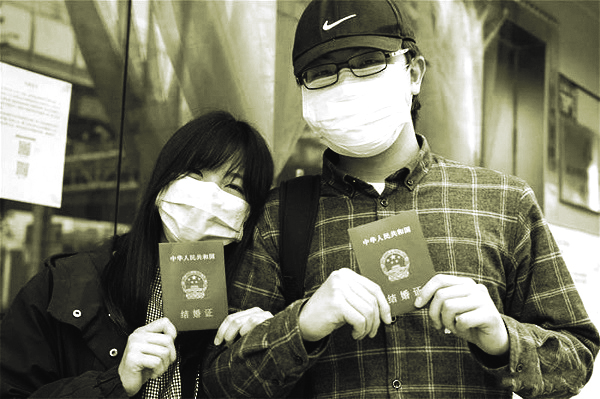 Anh Lu và vợ, cô Đinh khoe giấy chứng nhận kết hôn tại văn phòng đăng ký kết hôn ở Vũ Hán