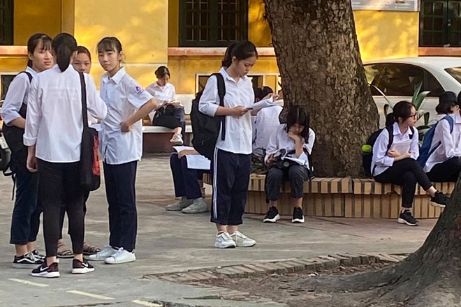 Tại điểm thi trường THPT Đống Đa, nhiều th&iacute; sinh tranh thủ &ocirc;n lại b&agrave;i trước khi v&agrave;o thi.