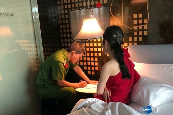 Công an lấy lời khai của một cô gái bán dâm bị bắt quả tang tại khách sạn. (Ảnh: Báo CAND)