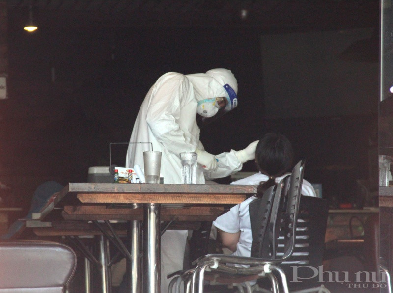 Cán bộ y tế lấy mẫu xét nghiệm trường hợp tiếp xúc gần với ca nghi nhiễm tại Hà Nội.