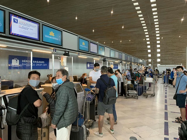 Hành khách đang làm thủ tục tại sân bay để về Việt Nam.