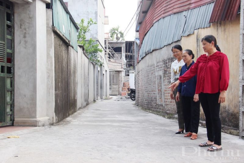 Chị Cao Thị Tĩnh (áo đỏ) cho biết, nơi chị đứng trước kia là đường đất, chỉ rộng 2m2 nhưng nay đã được bê tông hóa kiên cố và mở rộng lòng đường nhờ bà con hiến đất.