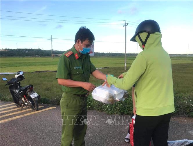Người dân xã Vĩnh Hòa trao những suất ăn, hỗ trợ lực lượng làm nhiệm vụ phong tỏa thôn Đơn Duệ. Ảnh: TTXVN phát