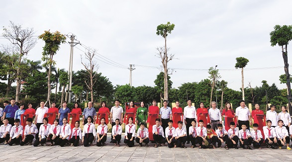 Các đồng chí lãnh đạo Hội LHPN Hà Nội, huyện Đông Anh cắt băng khánh thành, chụp ảnh cùng các em học sinh tại lê bàn giao sân chơi cộng đồng tại thôn Thượng Phúc xã Bắc Hồng