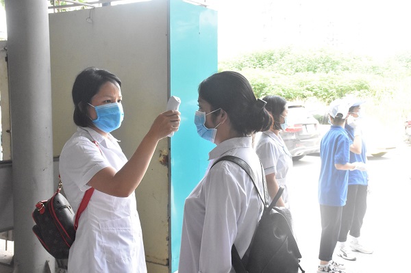 Các thí sinh đeo khẩu trang, được đo thân nhiệt khi vào phòng thi