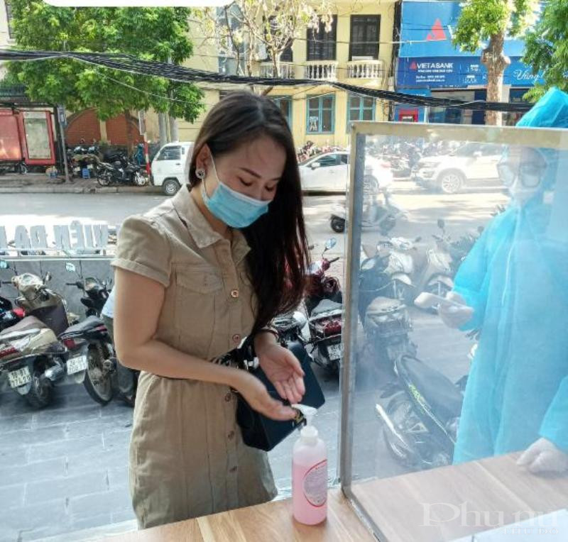 Người dân tới khám tại BV Đa khoa Hà Nội sát khuẩn tay trước khi vào làm thủ tục khám.