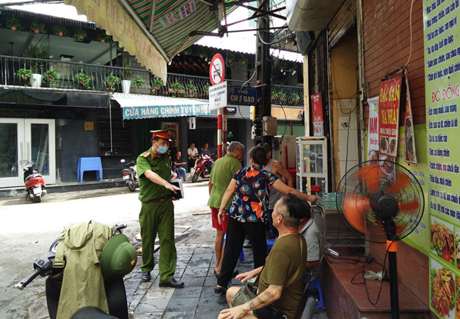 C&ocirc;ng an quận Ho&agrave;n Kiếm nhắc nhở người d&acirc;n đeo khẩu trang nơi c&ocirc;ng cộng.