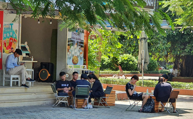 Qu&aacute;n tr&agrave; chanh tại khu vực t&ograve;a nh&agrave; CT8A (phường Văn Qu&aacute;n, H&agrave; Đ&ocirc;ng), kh&aacute;ch ngồi t&uacute;m tụm, kh&ocirc;ng đeo khẩu trang.