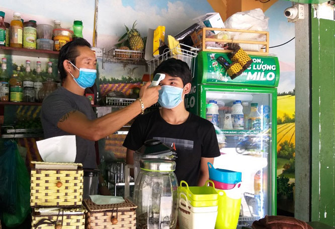 Đo th&acirc;n nhiệt cho kh&aacute;ch ở qu&aacute;n c&agrave; ph&ecirc; Valballa (số 40 phố Kh&uacute;c Thừa Dụ, quận Cầu Giấy).