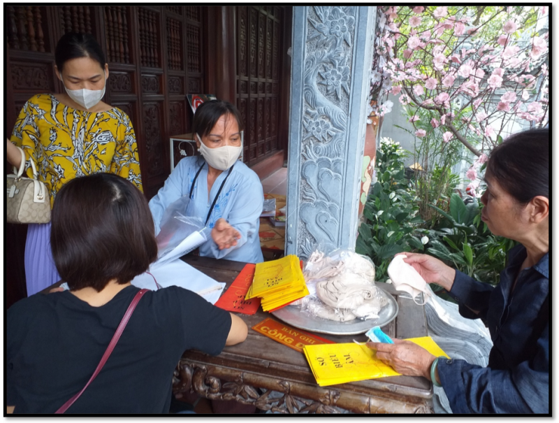 Người dận được yêu cầu sát khuẩn tay và nhận khẩu trang miễn phí trước khi vào lễ tại chùa Vạn Niên
