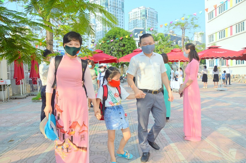 Học sinh trường tiểu học  Pascal đến trường trong vòng tay yêu thương của bố mẹ, cô giáo