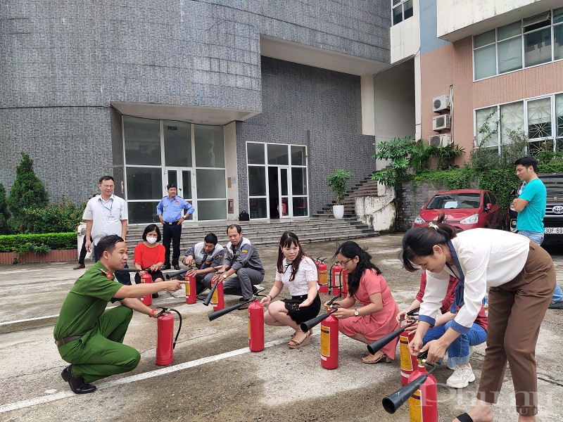 C&aacute;c đồng ch&iacute; trong đội cảnh s&aacute;t Ph&ograve;ng ch&aacute;y chữa ch&aacute;y v&agrave; Cứu nạn cứu hộ C&ocirc;ng an quận Cầu Giấy hướng dẫn c&aacute;ch sử dụng b&igrave;nh cứu hỏa