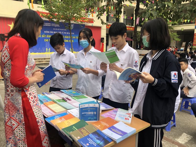 Các em học sinh tìm hiểu tài liệu, tờ rơi phổ biến kiến thức về pháp luật và an toàn cho phụ nữ, trẻ em